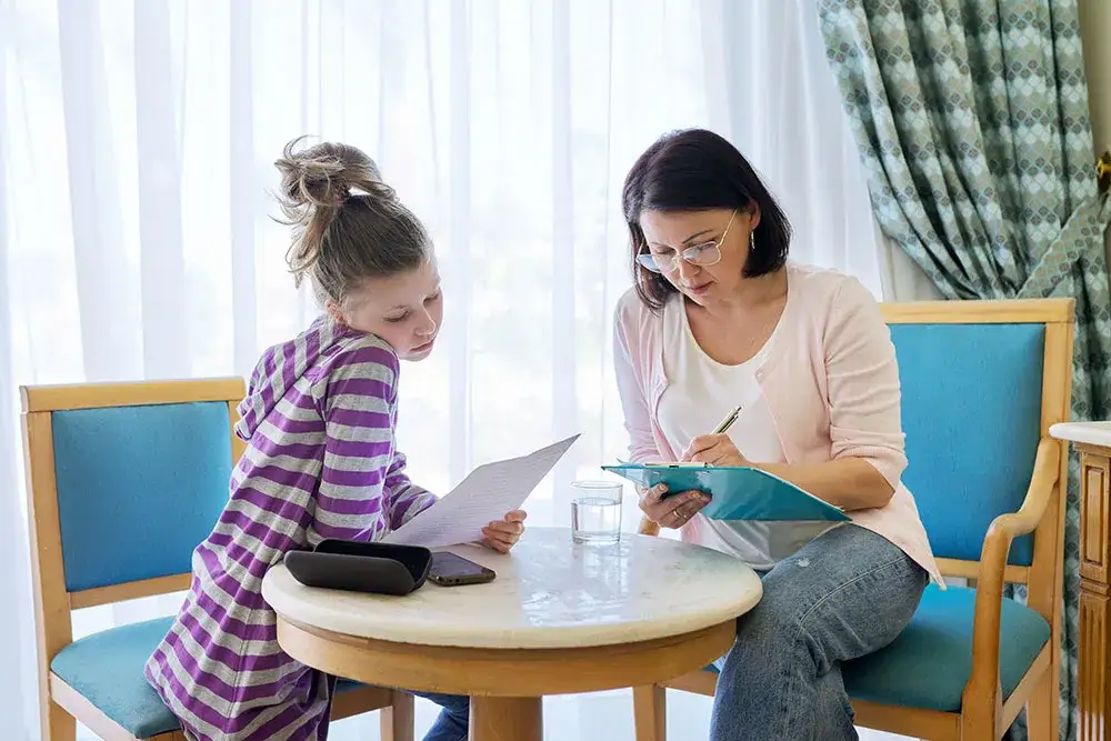 Rodzic z dzieckiem i dokumentami w poradni psychologiczno-pedagogicznej